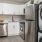 Spacious and well lit kitchen with wood floors and stainless steel appliances 