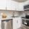 Spacious and well lit kitchen with wood floors and stainless steel appliances 