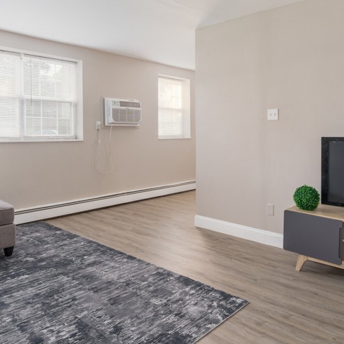 Living Room Spacious and well lit living room with wood floors and a large window with access to the kitchen